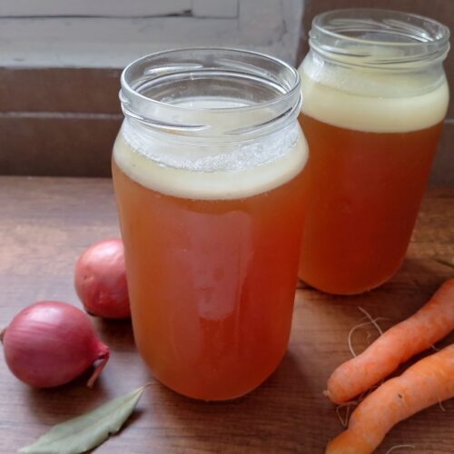 Lamb bone broth in jars on wooden table