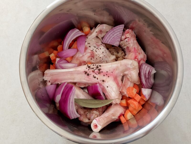 Lamb bones and vegetables in pot
