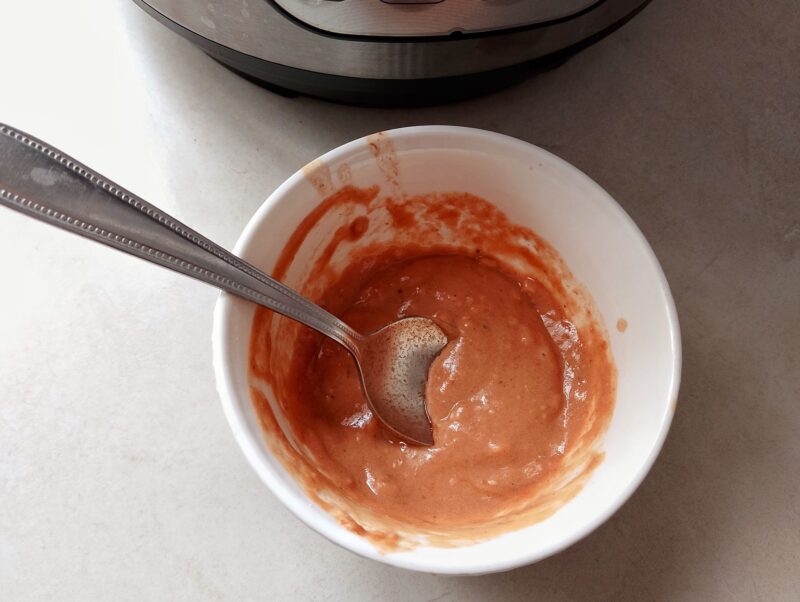 Mixing flour with some sauce to thicken baked beans