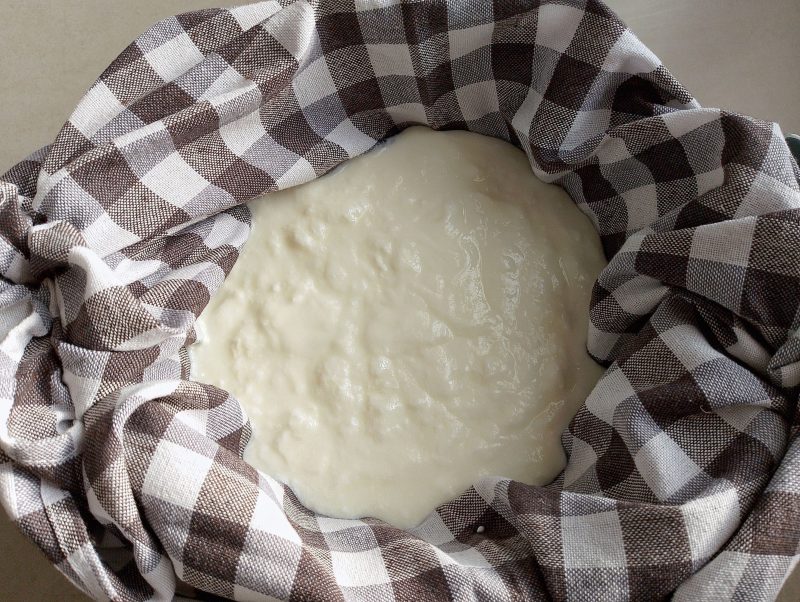 Yogurt draining in colander lined with a tea towel